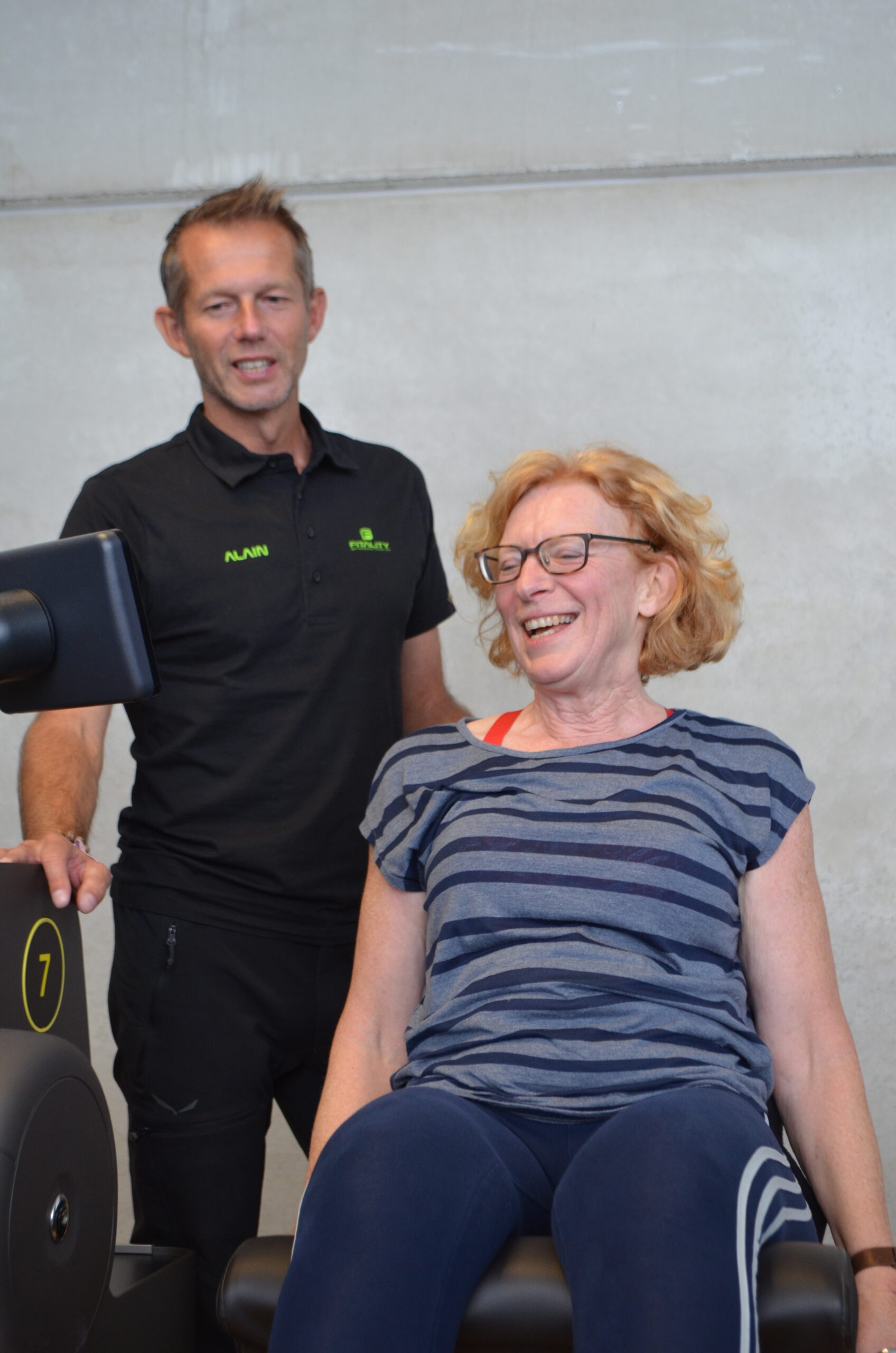 Coach begeleidt een vrouw tijdens krachttraining op een Biocircuit toestel bij Fitality