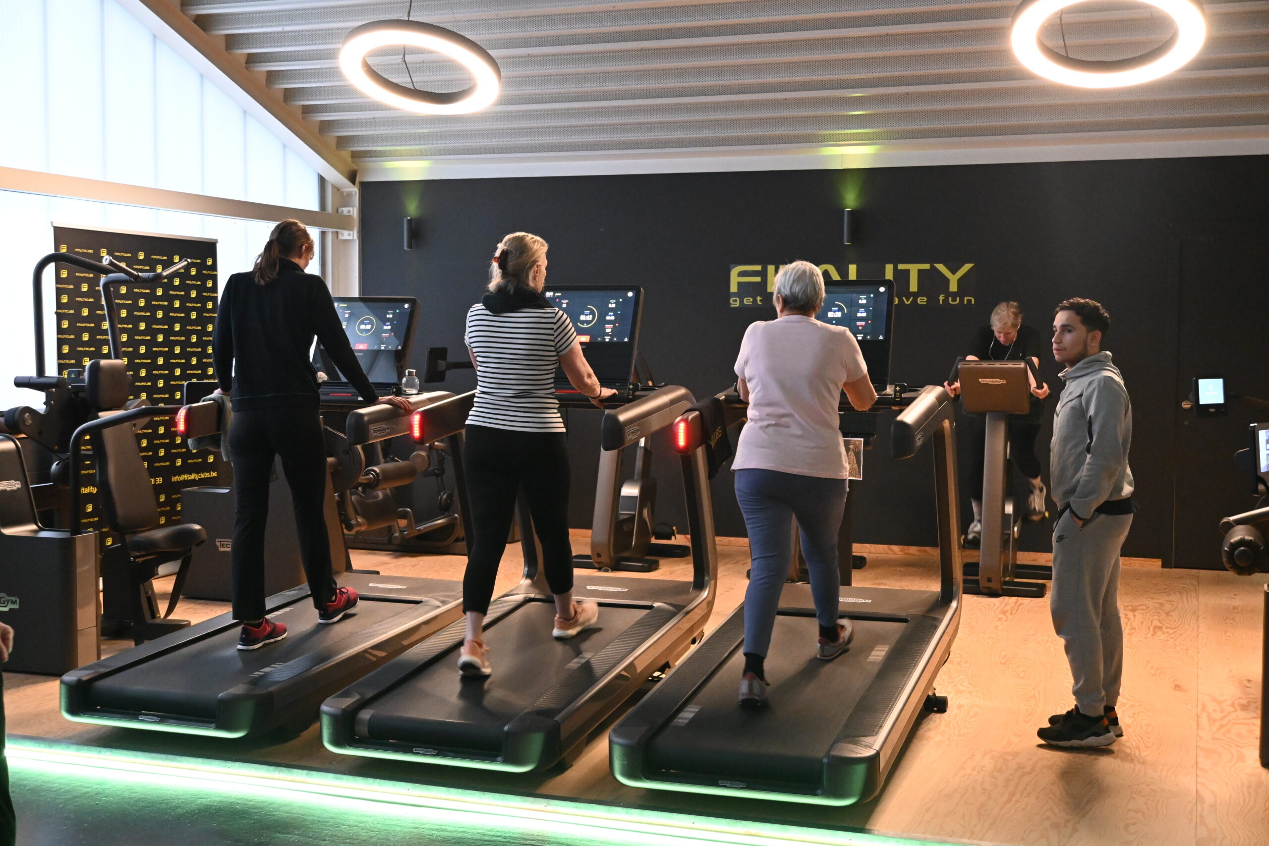 Drie vrouwen van in de veertig trainen samen op de loopband bij Fitality