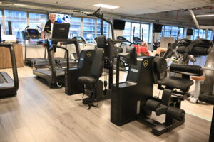 Man traint zijn benen op een krachttoestel tijdens de circuittraining bij Fitality
