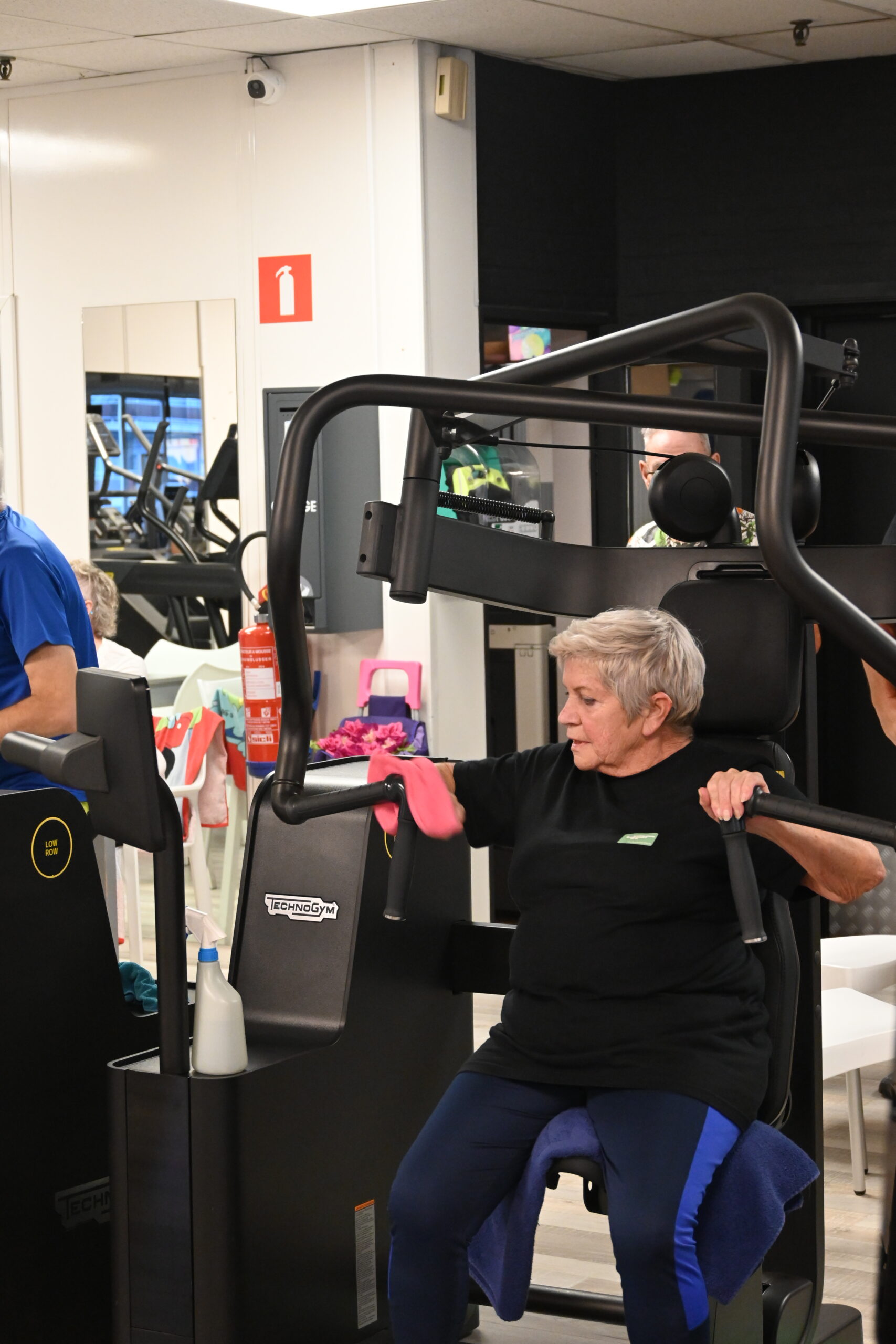 Oudere vrouw traint haar bovenlichaam op een Technogym chest press bij Fitality