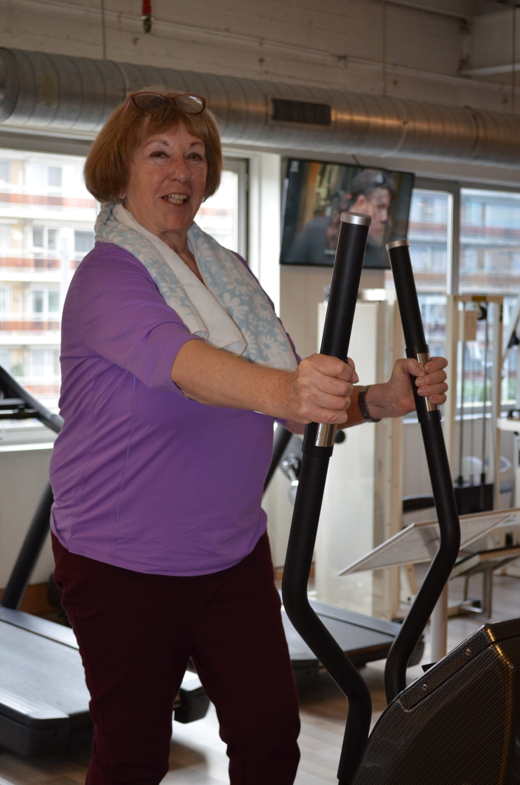 Vrouw traint in een rustig tempo op de crosstrainer bij Fitality