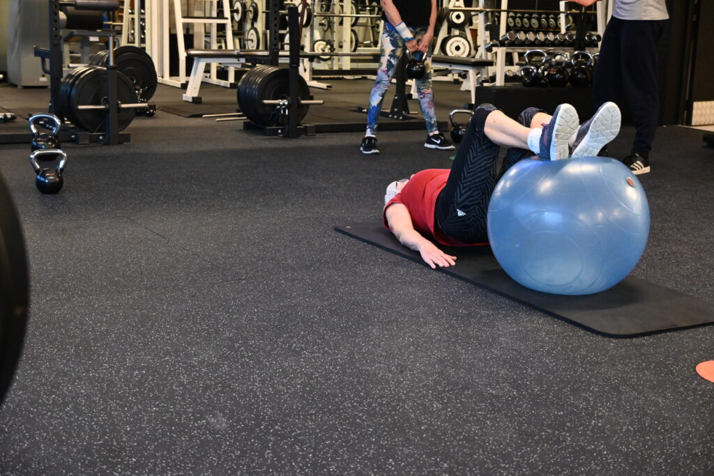 Twee leden doen functionele training met kettlebells in een kleine groep