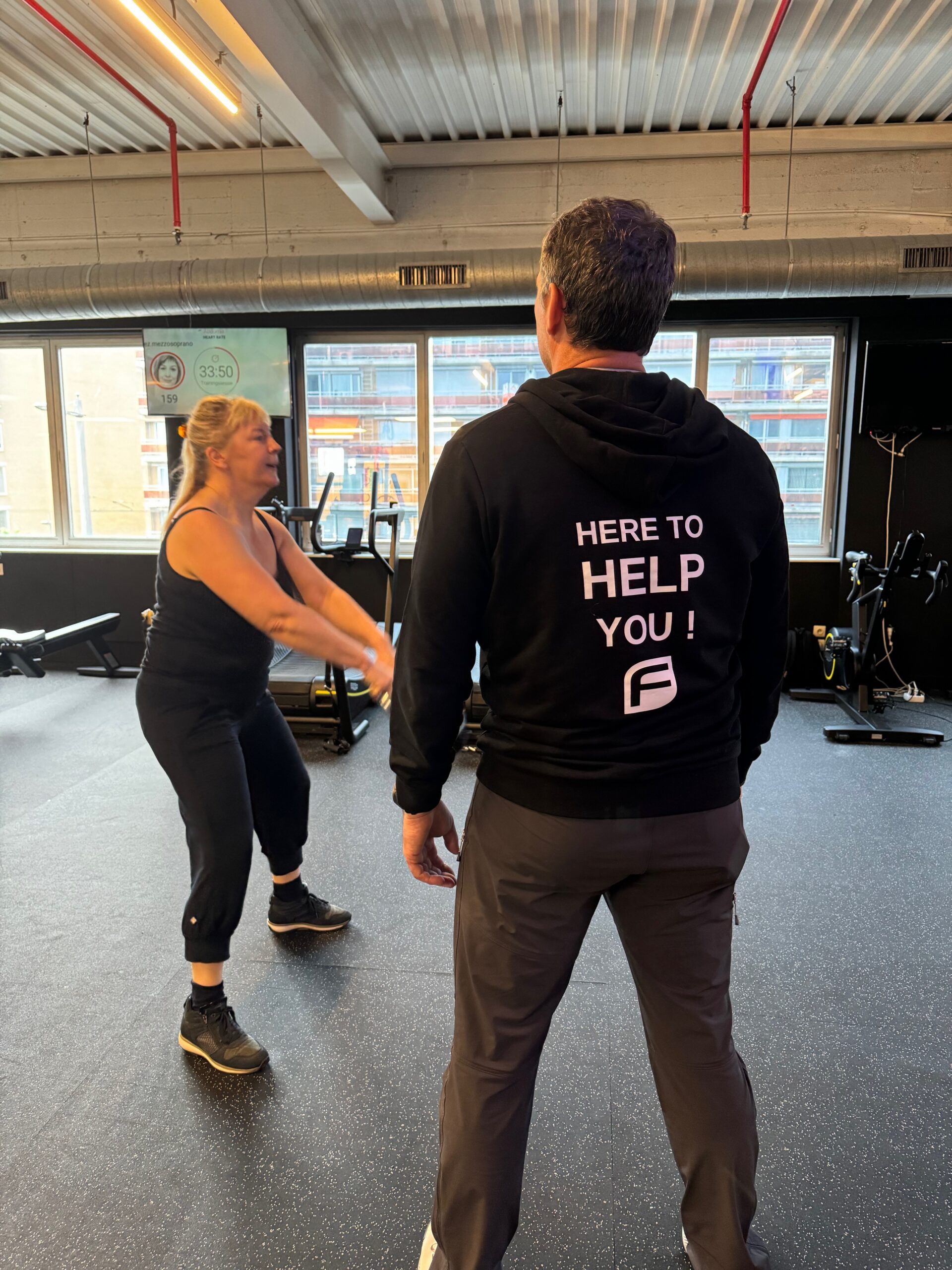 Coach corrigeert de squat van een lid tijdens personal training