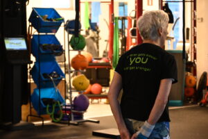 Vrouw van 60-plus doet een functionele oefening in de trainingszaal