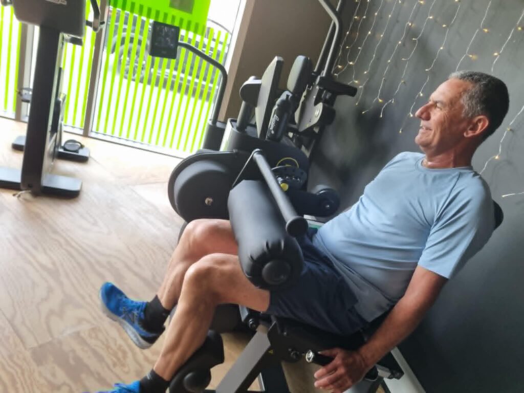 Man traint zijn bovenbeenspieren op de leg extension bij Fitality