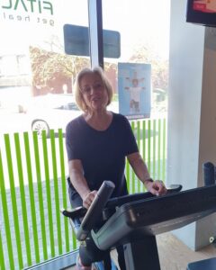 Vrouw traint in een rustig tempo op een cardiotoestel bij Fitality