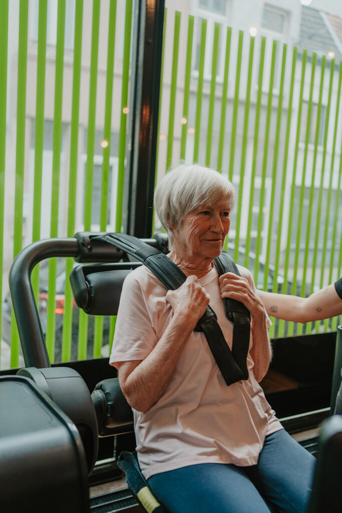 Vrouw traint in beheerst tempo op een toestel van het circuit bij Fitality